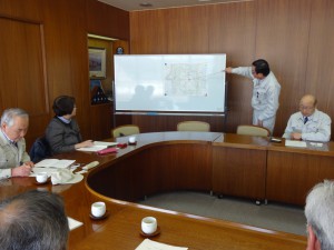 佐々木総務課長から説明を受ける調査団。写真右は佐藤副町長。